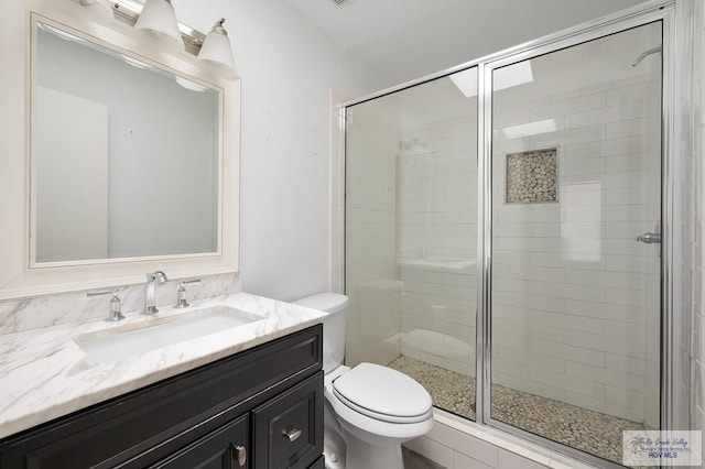 bathroom featuring an enclosed shower, vanity, and toilet