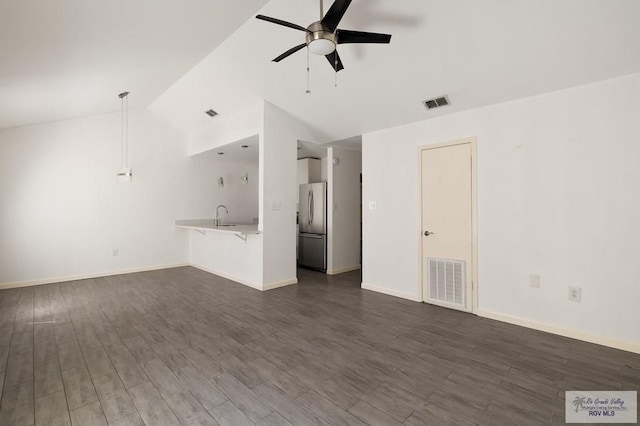 unfurnished living room with dark hardwood / wood-style flooring, vaulted ceiling, ceiling fan, and sink