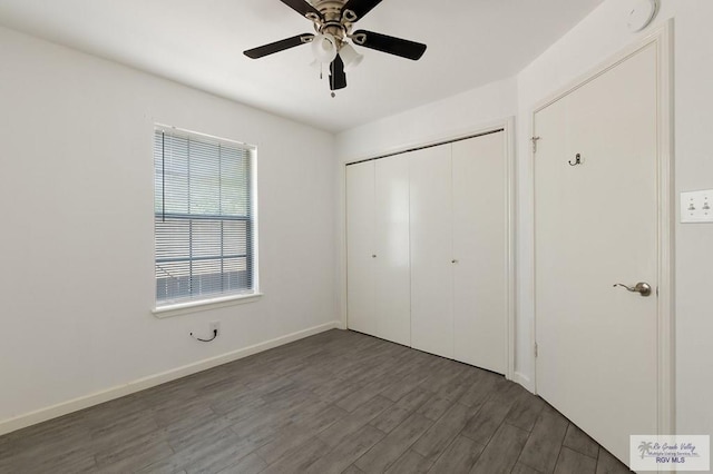 unfurnished bedroom with ceiling fan, a closet, and dark wood-type flooring