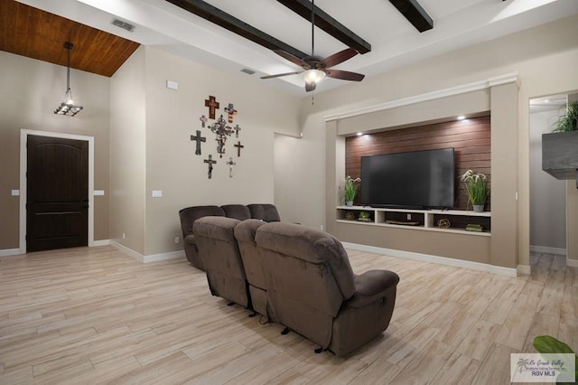 living room featuring beam ceiling, light wood-type flooring, ceiling fan, and a high ceiling