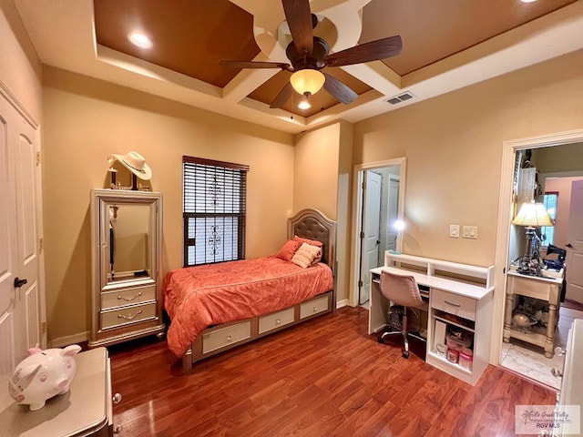 bedroom featuring ceiling fan, dark hardwood / wood-style floors, a raised ceiling, and coffered ceiling