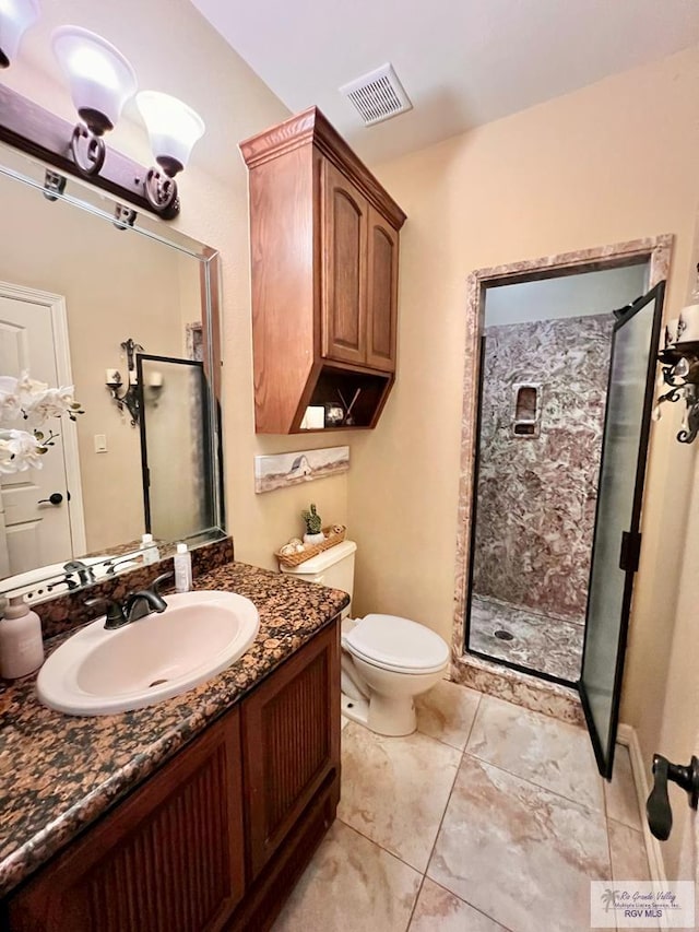 bathroom with a shower with door, vanity, and toilet