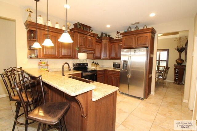 kitchen with a breakfast bar, sink, hanging light fixtures, appliances with stainless steel finishes, and kitchen peninsula