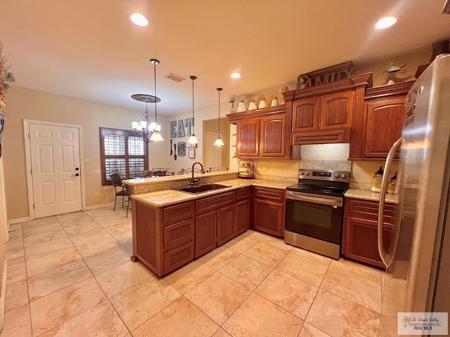 kitchen featuring pendant lighting, sink, appliances with stainless steel finishes, kitchen peninsula, and a chandelier