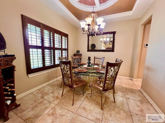 dining room with a tray ceiling and a chandelier