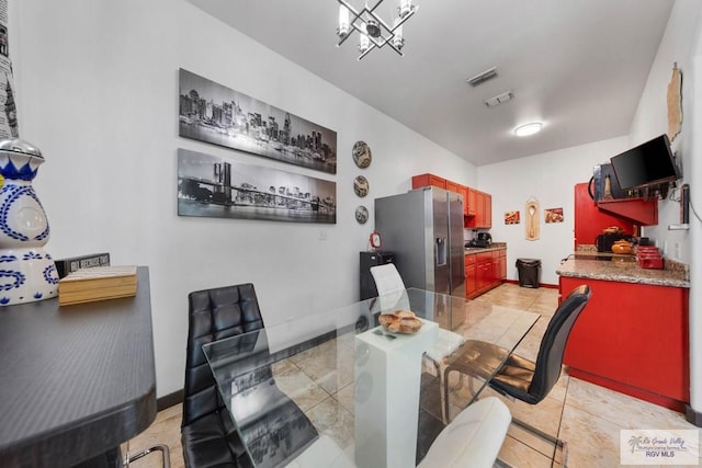 tiled dining room with a notable chandelier