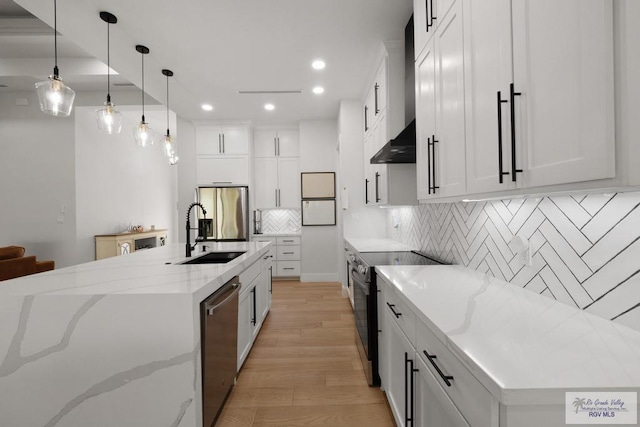 9073 New Orleans Ct, Los Fresnos, TX 78566 - kitchen featuring stainless steel appliances, a sink, light wood-type flooring, recessed lighting, and backsplash