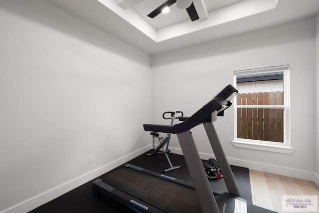 9073 New Orleans Ct, Los Fresnos, TX 78566 - workout area featuring a raised ceiling, ceiling fan, baseboards, and wood finished floors