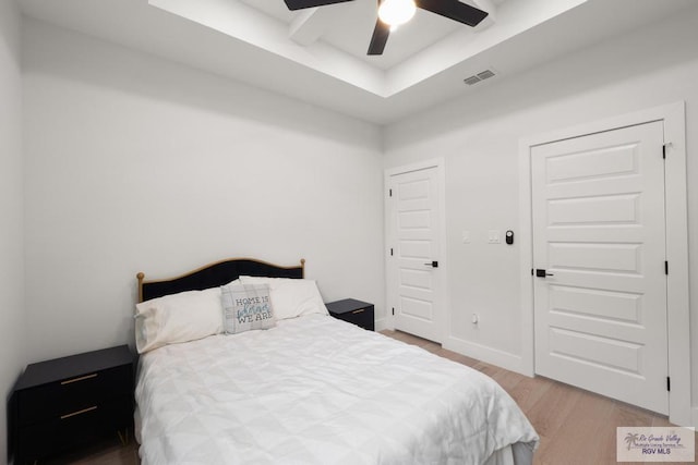 9073 New Orleans Ct, Los Fresnos, TX 78566 - bedroom featuring wood finished floors, a tray ceiling, and a ceiling fan