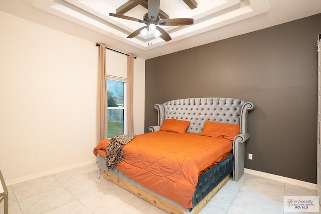 bedroom with a raised ceiling and ceiling fan