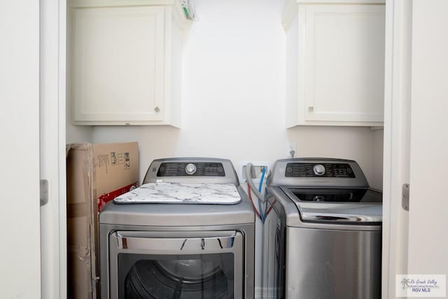 laundry room featuring washing machine and dryer and cabinets