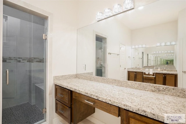 bathroom with vanity and a shower with door