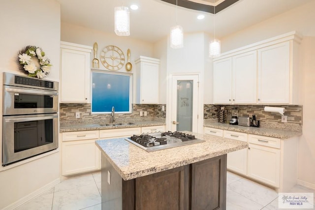 kitchen featuring a kitchen island, decorative light fixtures, sink, white cabinets, and stainless steel appliances