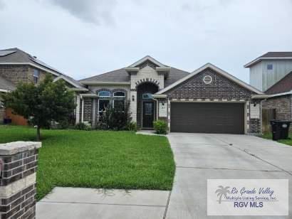 2104 Tomatillo Dr, Weslaco, TX 78596 - view of front of home with an attached garage, a front lawn, and driveway