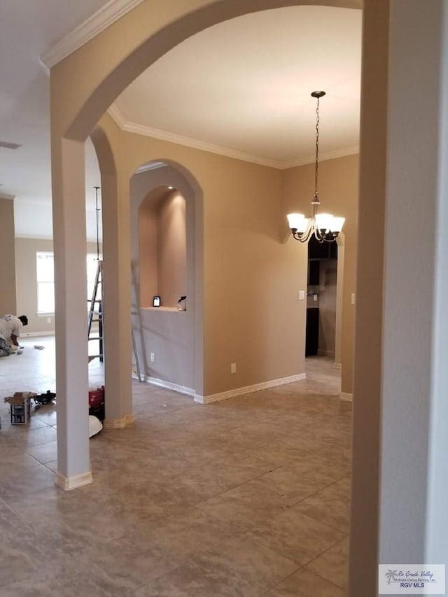 2104 Tomatillo Dr, Weslaco, TX 78596 - spare room with crown molding, arched walkways, a chandelier, and baseboards