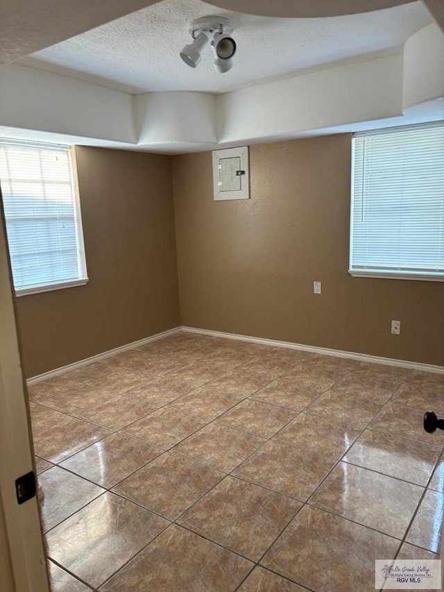 basement with light tile patterned floors and a textured ceiling