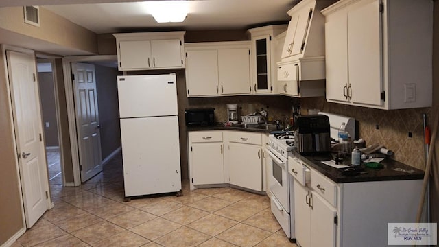 kitchen featuring white cabinetry, light tile patterned flooring, white appliances, and backsplash