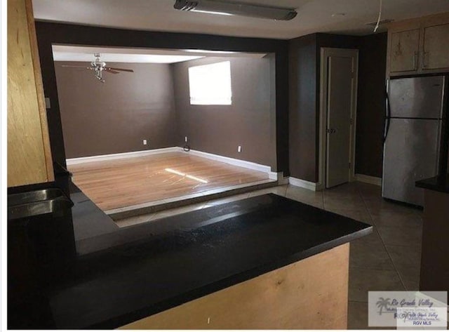 basement with hardwood / wood-style flooring and stainless steel refrigerator