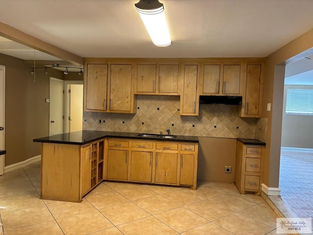 kitchen with sink, backsplash, kitchen peninsula, and light tile patterned floors