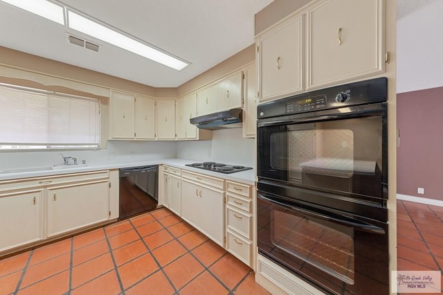 kitchen featuring cream cabinets, sink, light tile patterned flooring, and black appliances