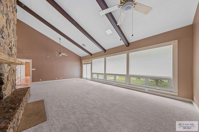 unfurnished living room featuring carpet, high vaulted ceiling, a stone fireplace, ceiling fan, and beam ceiling