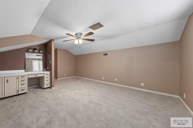 bonus room with ceiling fan, light colored carpet, lofted ceiling, and a textured ceiling