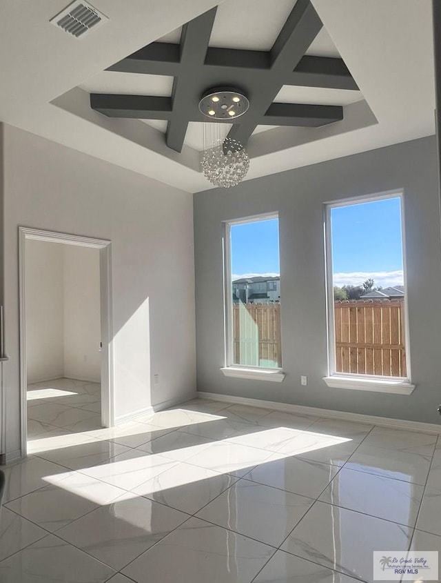 unfurnished room featuring coffered ceiling and beam ceiling