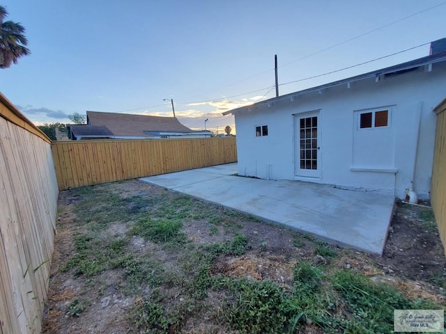 yard at dusk featuring a patio