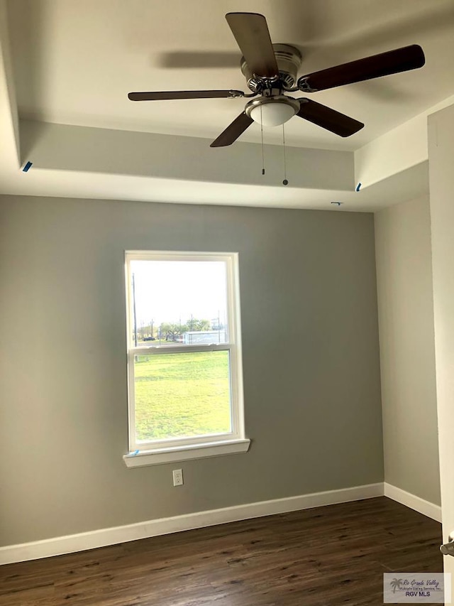 spare room with ceiling fan and dark wood-type flooring