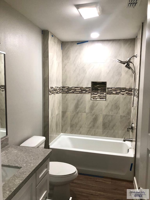 full bathroom featuring wood-type flooring, vanity, and tiled shower / bath