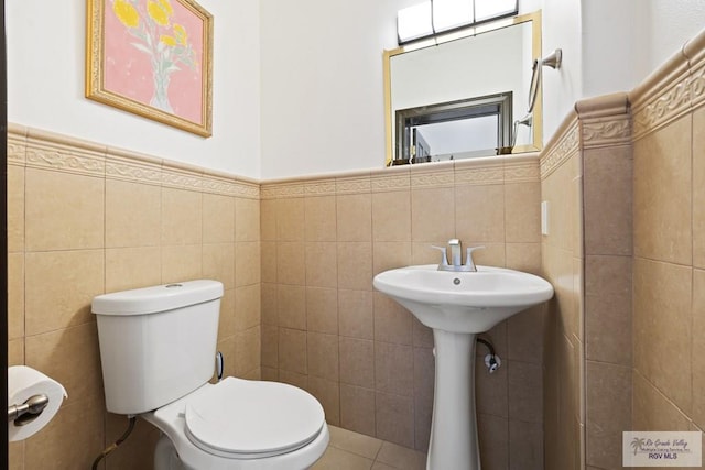 bathroom featuring tile walls and toilet