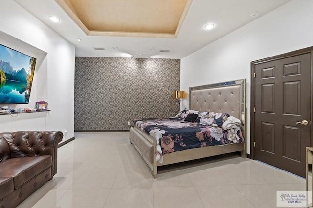 tiled bedroom featuring a tray ceiling and tile walls