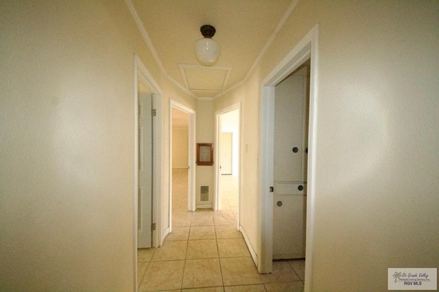 hallway with crown molding and light tile patterned floors