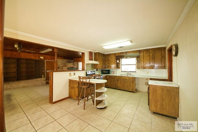 kitchen with sink, a breakfast bar area, stainless steel range with electric stovetop, ornamental molding, and a kitchen island