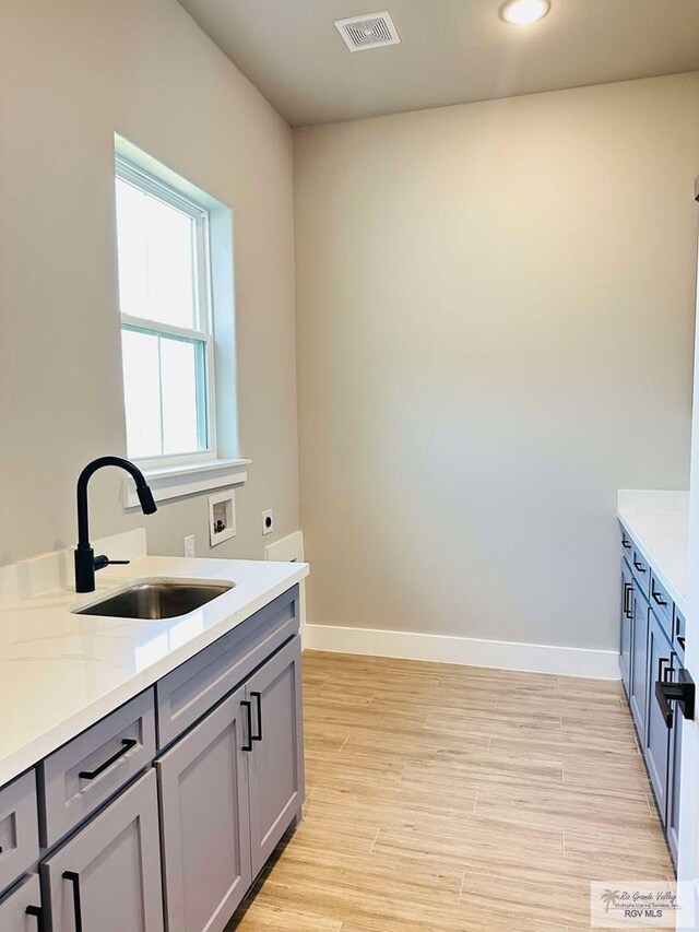 3414 Bryan Dr, Harlingen, TX 78550 - laundry area featuring a sink, hookup for an electric dryer, visible vents, washer hookup, and light wood-style floors