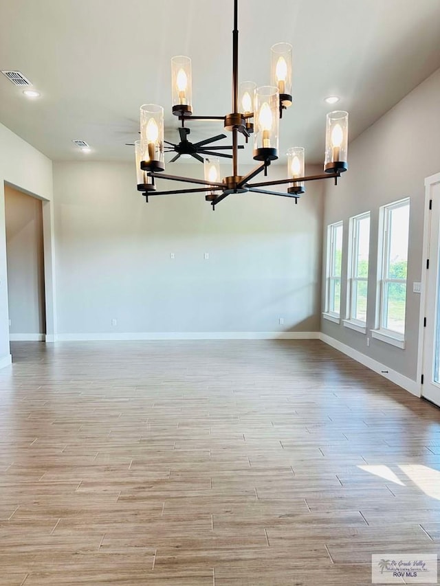 3414 Bryan Dr, Harlingen, TX 78550 - unfurnished dining area with baseboards, a notable chandelier, light wood-style flooring, and visible vents