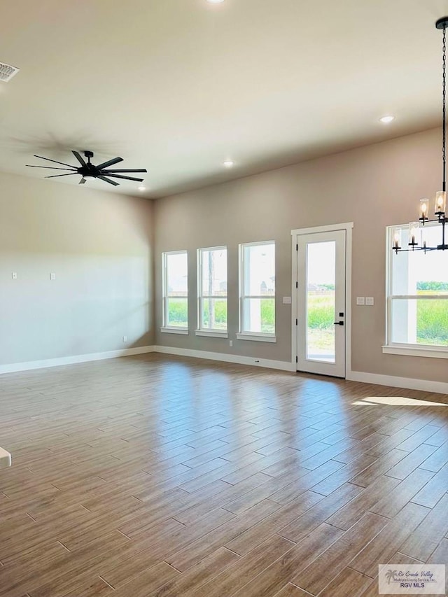 3414 Bryan Dr, Harlingen, TX 78550 - unfurnished living room with recessed lighting, baseboards, visible vents, ceiling fan with notable chandelier, and wood finished floors
