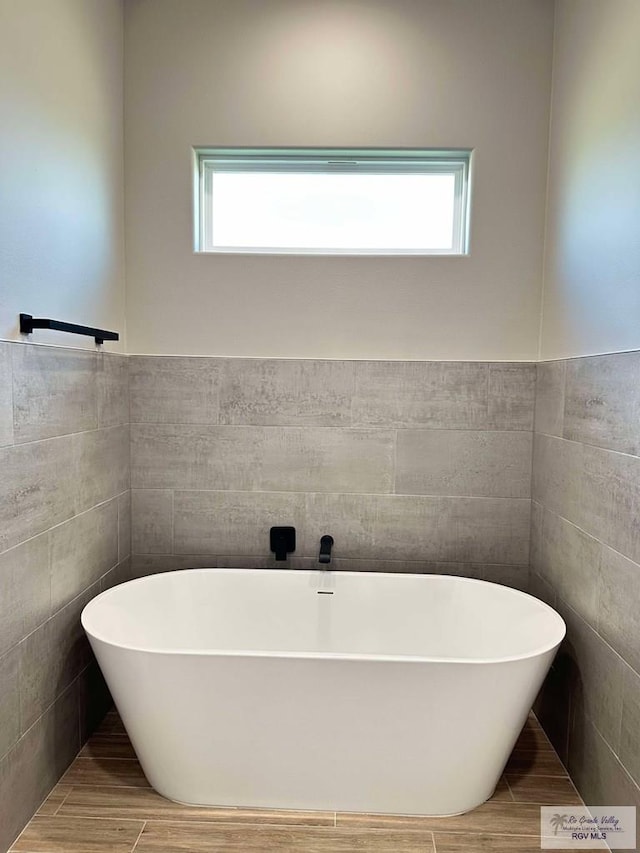 3414 Bryan Dr, Harlingen, TX 78550 - full bath featuring tile walls, a freestanding tub, and a wealth of natural light