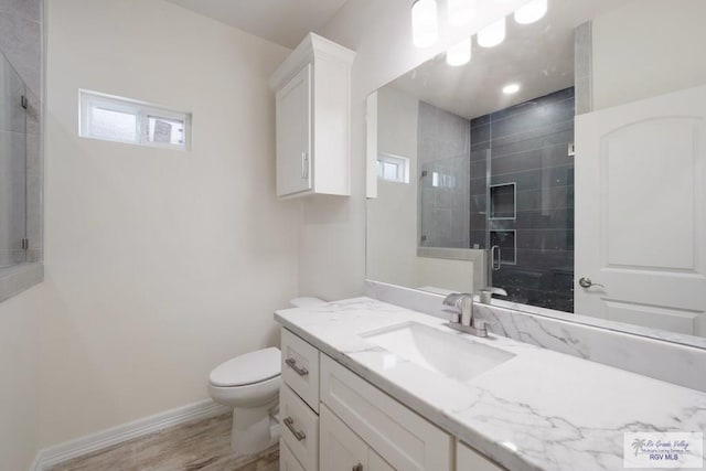 9817 Heights N, Harlingen, TX 78552 - full bath with a shower stall, toilet, vanity, wood finished floors, and baseboards