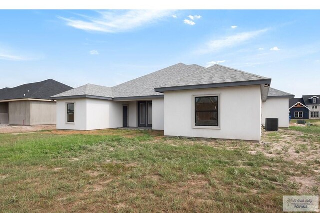 9817 Heights N, Harlingen, TX 78552 - back of house featuring roof with shingles, a lawn, stucco siding, and cooling unit