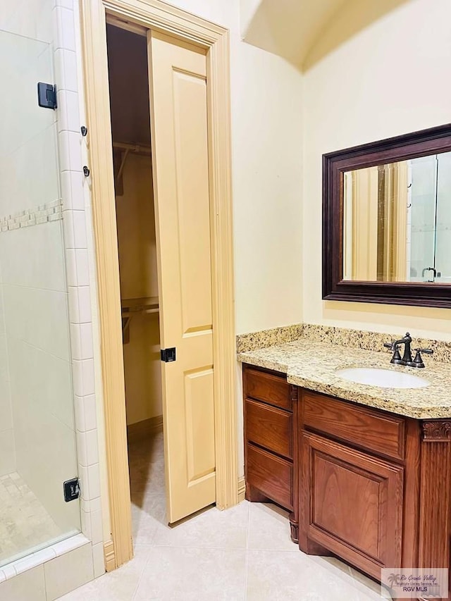 7232 Lago Viejo Blvd, Brownsville, TX 78520 - bathroom featuring a stall shower, tile patterned flooring, a walk in closet, and vanity