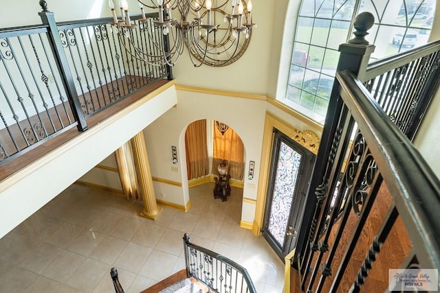 entrance foyer with an inviting chandelier, tile patterned floors, and a healthy amount of sunlight