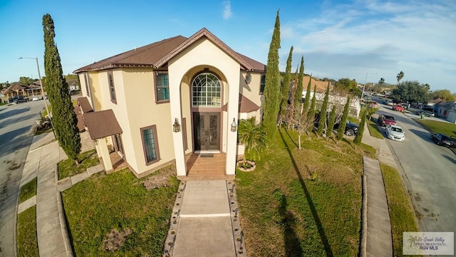 mediterranean / spanish-style house with a front yard