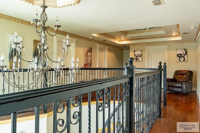 corridor with crown molding, dark hardwood / wood-style floors, and a tray ceiling