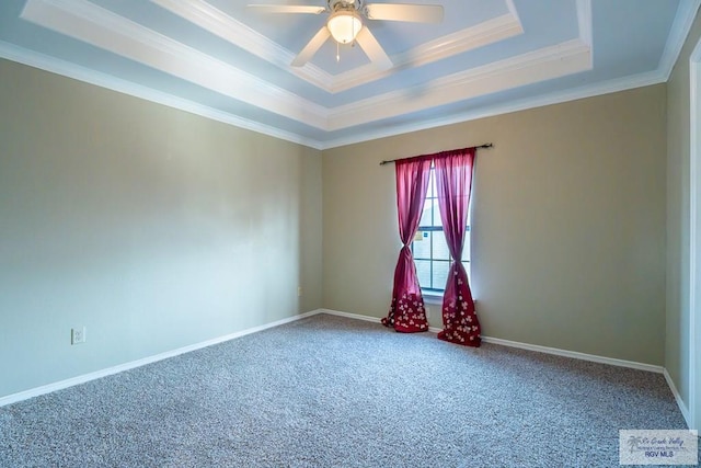 carpeted spare room with ornamental molding, ceiling fan, and a tray ceiling