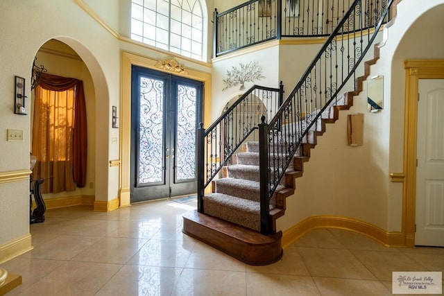 tiled foyer entrance featuring french doors and a high ceiling