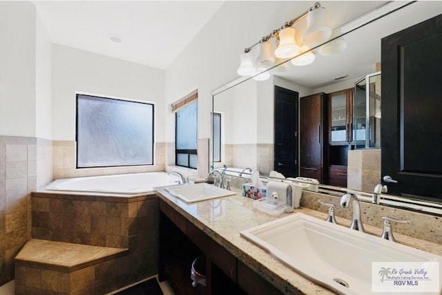 bathroom with tiled bath and vanity