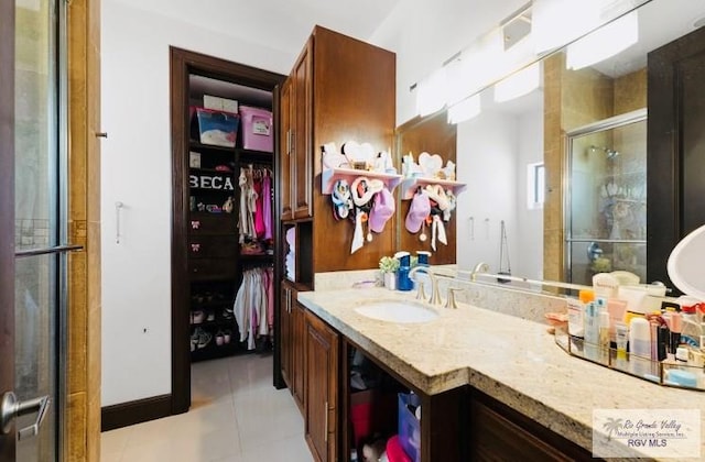 bathroom featuring tile patterned flooring, vanity, and an enclosed shower