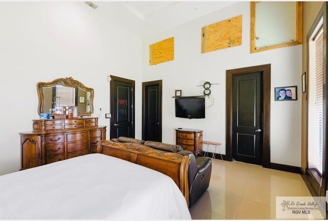 tiled bedroom featuring a high ceiling