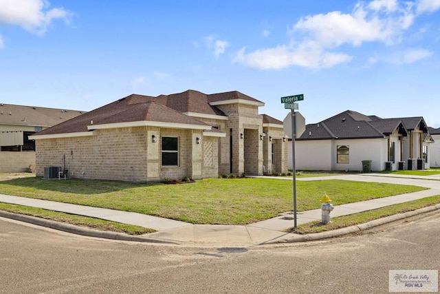5112 Blackhawk Ave, Rio Grande City, TX 78582 - view of front of property featuring cooling unit, a shingled roof, brick siding, and a front yard
